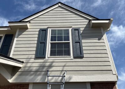 Windows on a tan house with brick viewed from the exterior